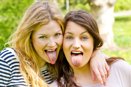 Two girls sticking tongue out dieses Bild zeigt zwei Frauen mit herausgestreckter Zunge